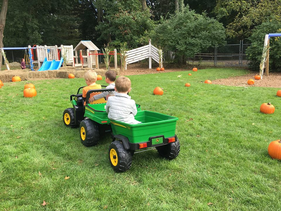 Students at the helm of a John Deere touring the pumpkin patch 